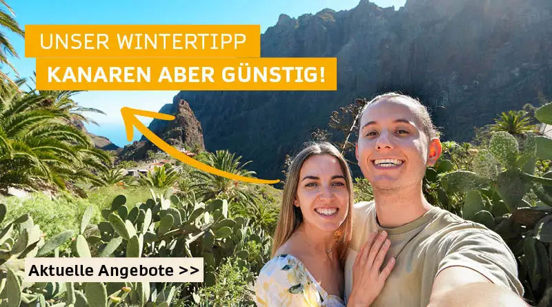 Selfie von einem glücklichen Pärchen in ihren 20igern auf Gran Kanaria an einem sonnigen Tag. Sie stehen in einem Tal umgeben von Kakteen. Im Hintergrund ist ein Berg zu sehen.  