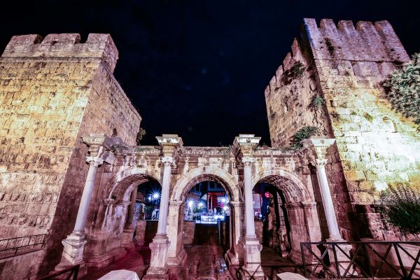 Frontale Aufnahme des Hadrianstors bei Nacht, einer der wichtigsten historischen Stätten in Antalya. Das Tor stammt aus dem Jahr 130 n. Chr. und ist ein Triumphbogen des Römischen Reiches.