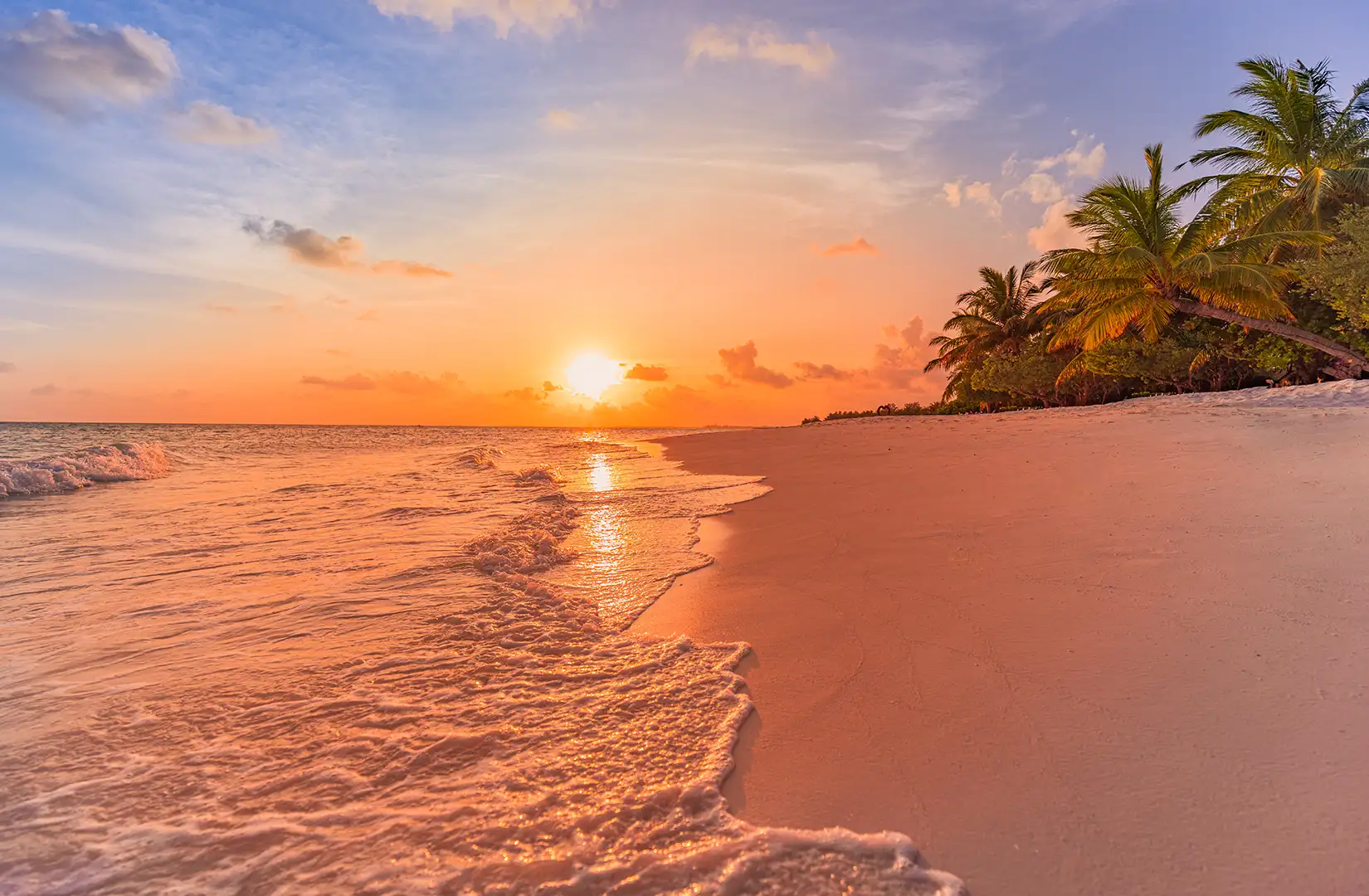 Karibische Inselstrandlandschaft mit ruhigen Meereswellen bei orangefarbenem Sonnenuntergang