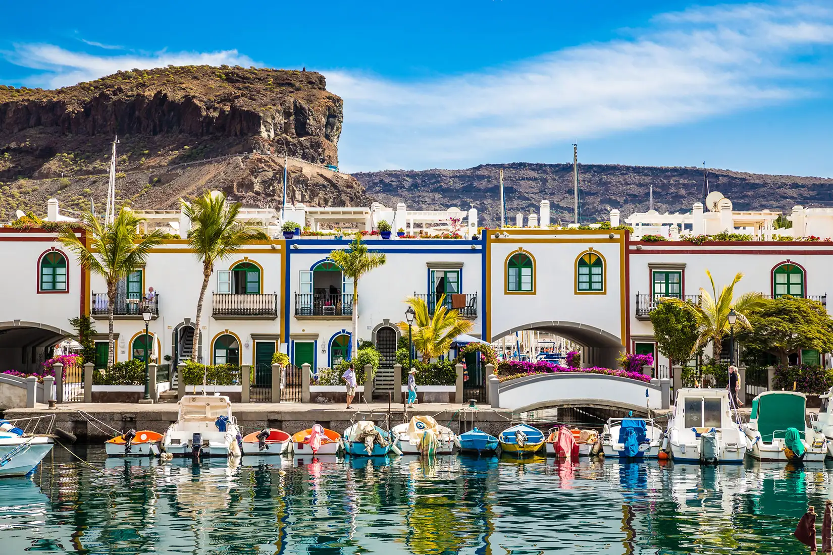 Traditionelle bunte Gebäude mit Booten davor in der Marina von Puerto de Mogan auf Gran Canaria