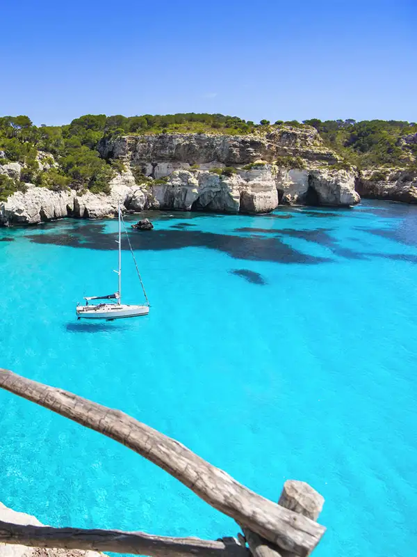 Blick auf Cala en Brut, einen Strand auf Menorca, mit türkisfarbenden Wasser