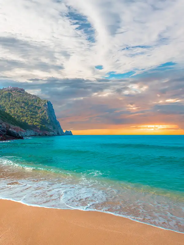 Strand von Kleopatra mit Meer und Felsen der Halbinsel Alanya